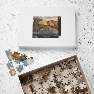 Mount Rushmore 250th Anniversary jigsaw puzzle in a white box, with scattered pieces showing mountain and sky designs.