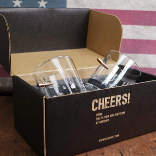 BenShot rocks glass set in a black box, featuring two clear glasses with copper accents and an American flag backdrop.