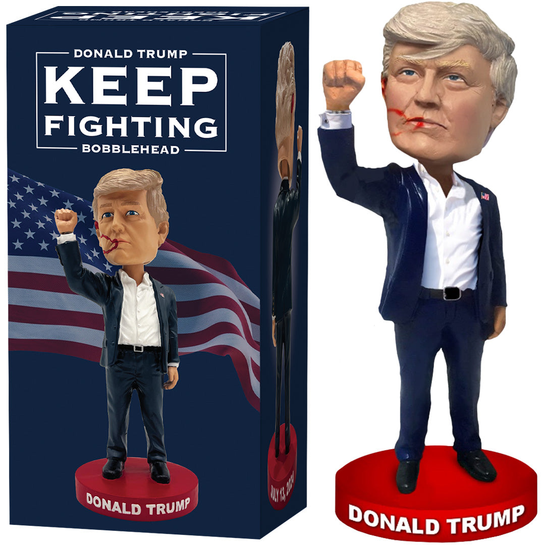 Keep Fighting bobblehead featuring a figure with blonde hair, raised fist, and suit, displayed beside its box.